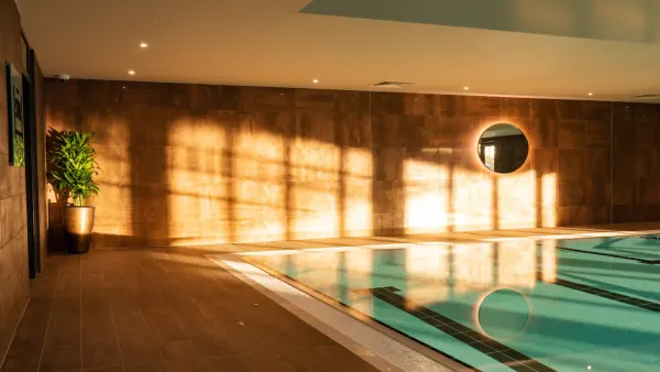 A man swimming as the afternoon sun beams in the pool