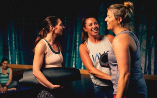 A group of people unwinding after a yoga class in a studio gym