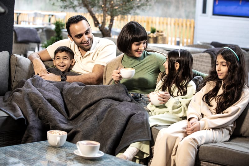 Family drinking hot chocolate on the terrace