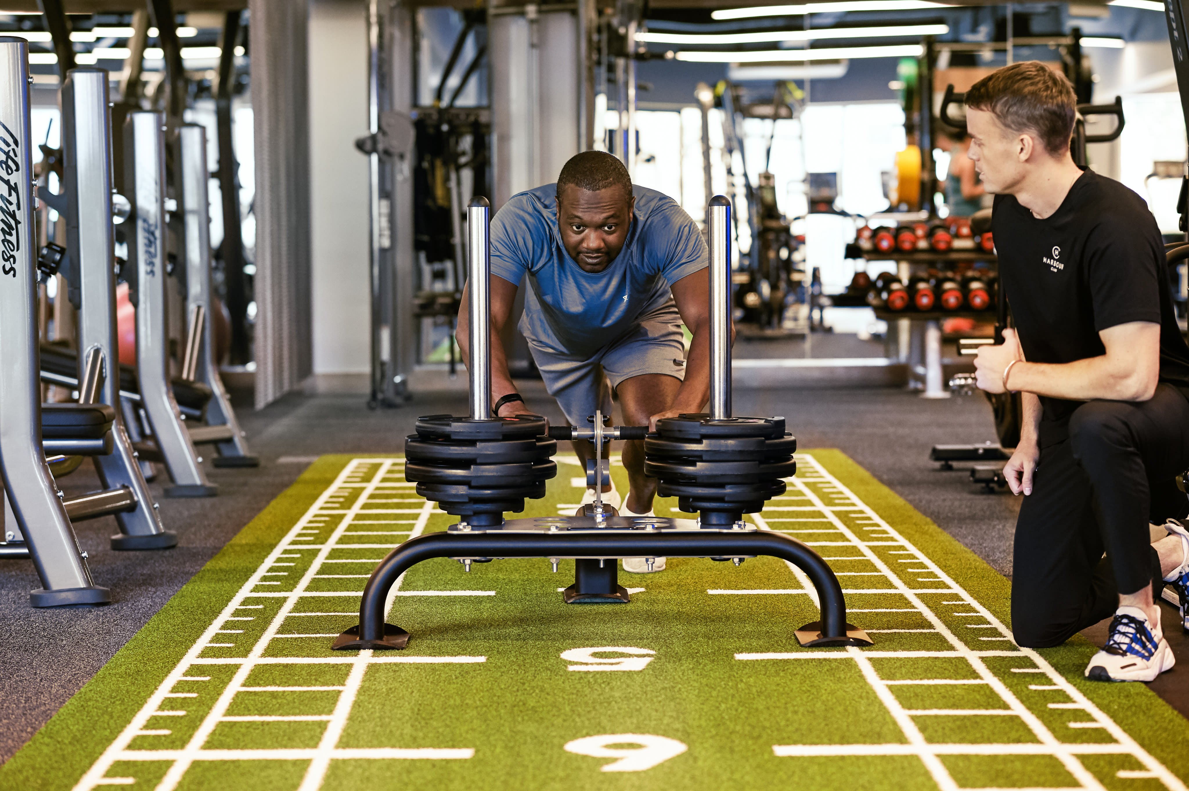 A man pushing a sled in the gym