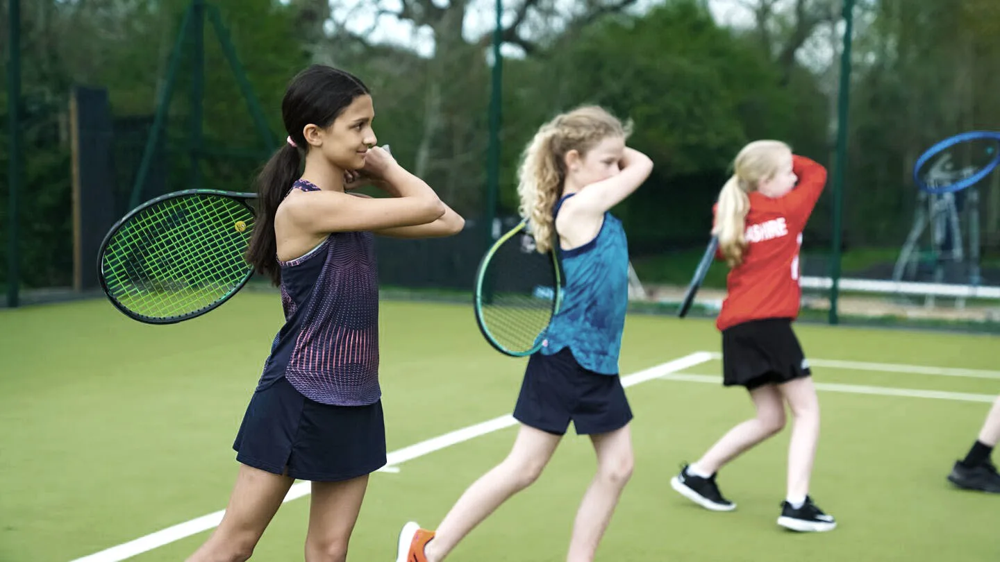 A young girl playing tennis