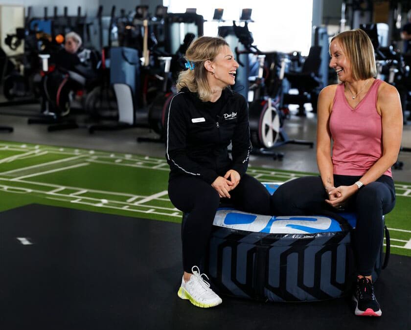 A woman laughing with her personal trainer