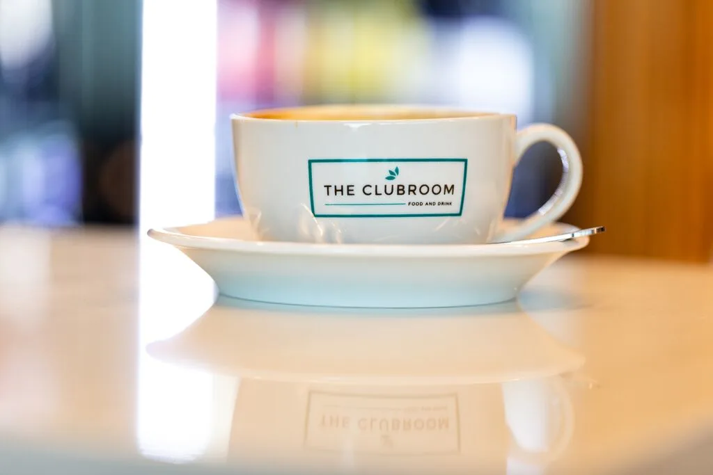 A coffee cup with 'The Clubroom' written on it.