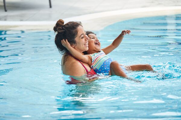 Woman and child swimming happily in a David Lloyd Clubs outdoor pool