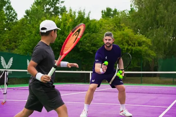 A tennis coach coaching a junior member